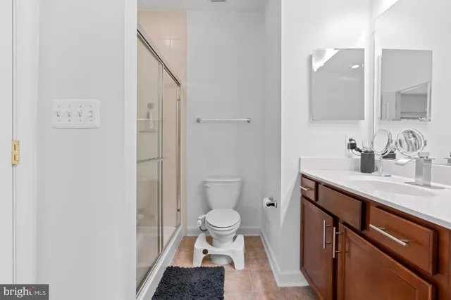 a bathroom with a sink a toilet a shower and a mirror