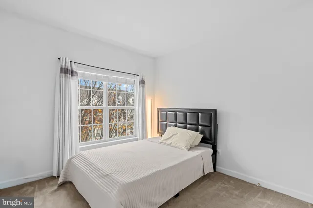 a bed sitting in a bedroom next to a window