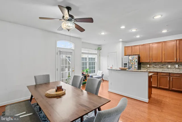 a kitchen with stainless steel appliances granite countertop a stove a sink a dining table and chairs