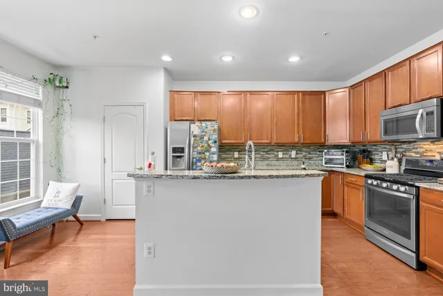 a kitchen with stainless steel appliances granite countertop a stove a sink and a refrigerator