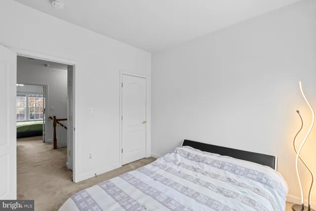 a bedroom with a bed and a view of living room