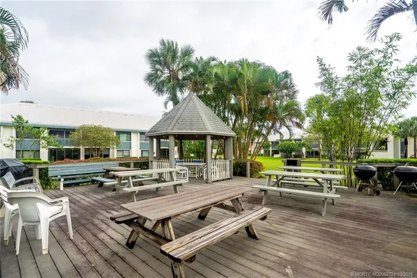 a view of swimming pool with lounge chair and dinning table under an umbrella