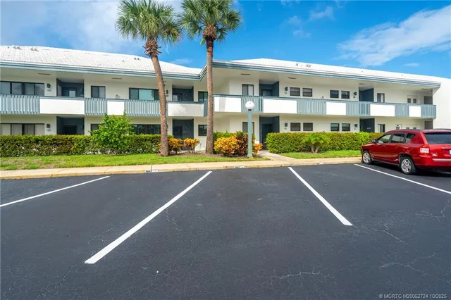 a front view of a house with a yard and potted plants