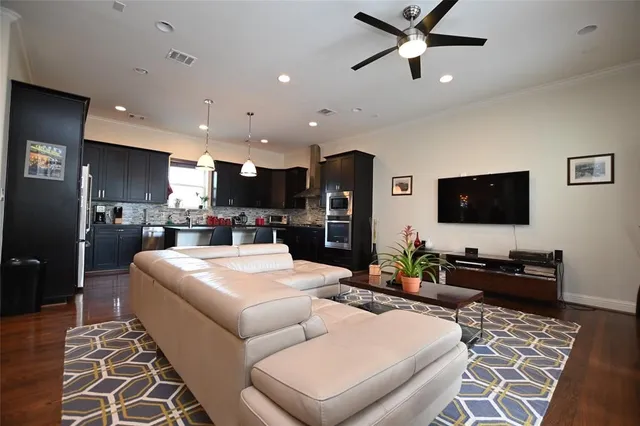 a living room with stainless steel appliances kitchen island granite countertop furniture and a rug
