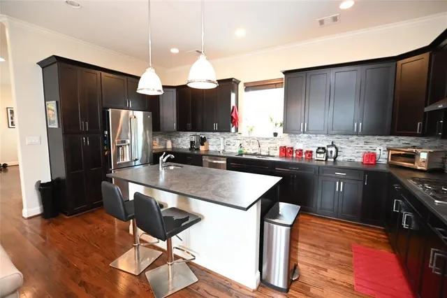 a kitchen with stainless steel appliances granite countertop a sink refrigerator and cabinets