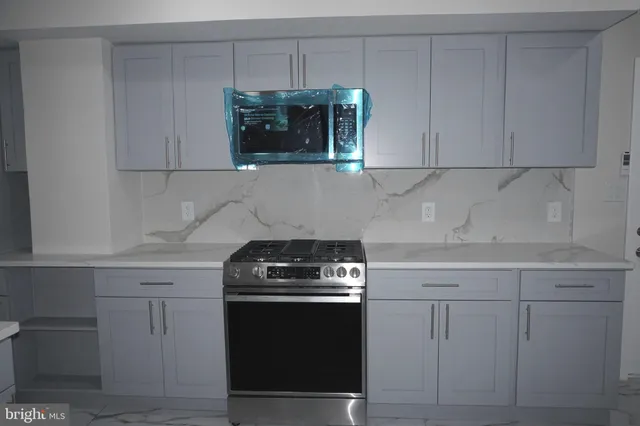 a kitchen with stainless steel appliances a sink stove and cabinets