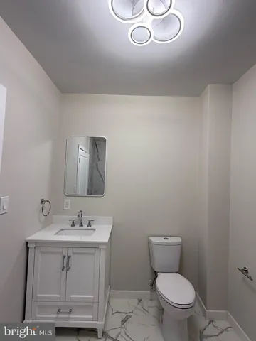 a bathroom with a sink toilet and mirror
