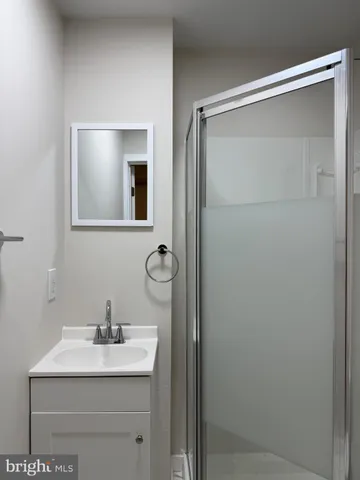a bathroom with a granite countertop sink and mirror