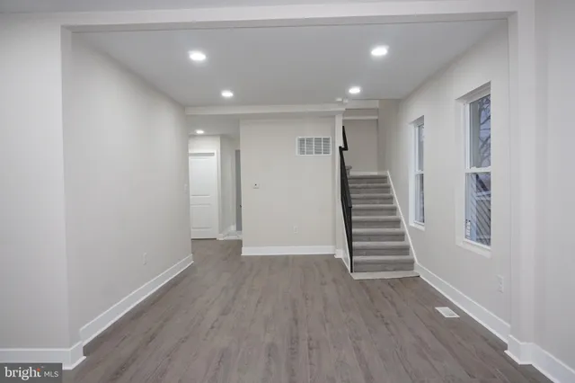 a kitchen with stainless steel appliances granite countertop a sink and a stove top oven with wooden floor