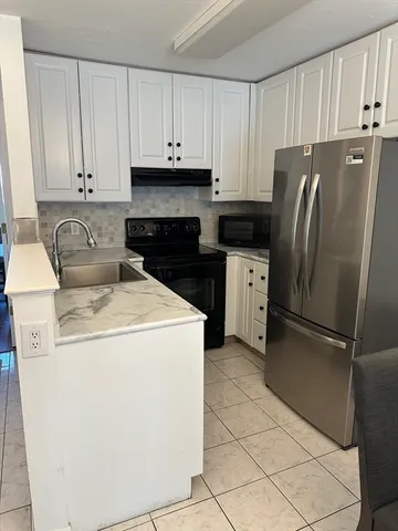 a kitchen with a refrigerator sink and cabinets