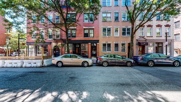 a view of building with cars parked in front of it