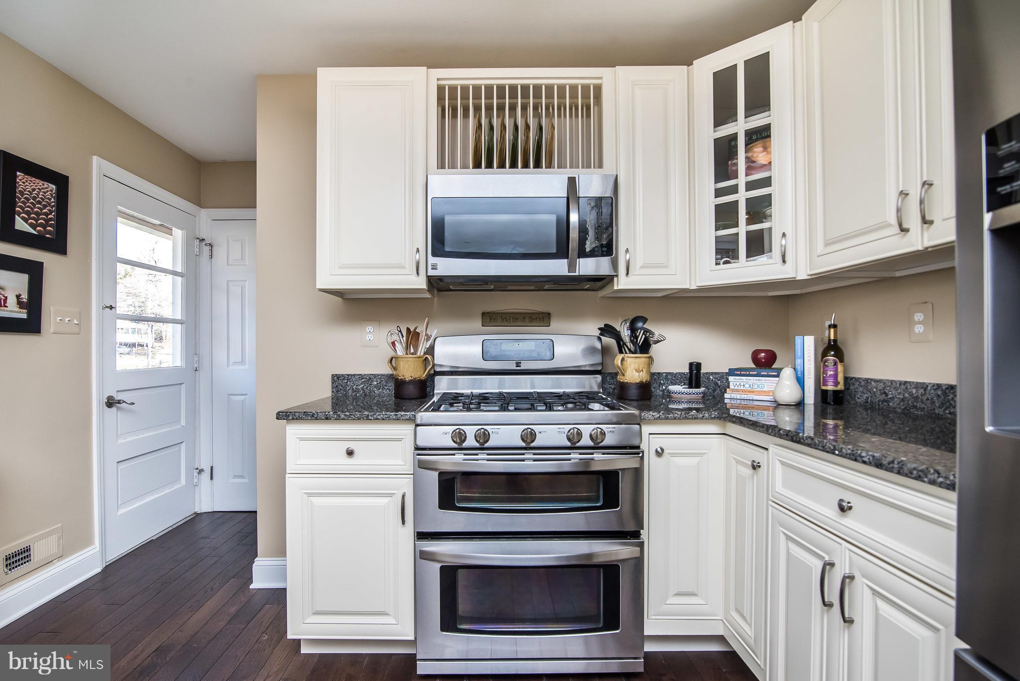 4042 High Point Road Ellicott City, MD 21042 - Photo 12 of 29 a kitchen with stainless steel appliances granite countertop white cabinets and a stove top oven