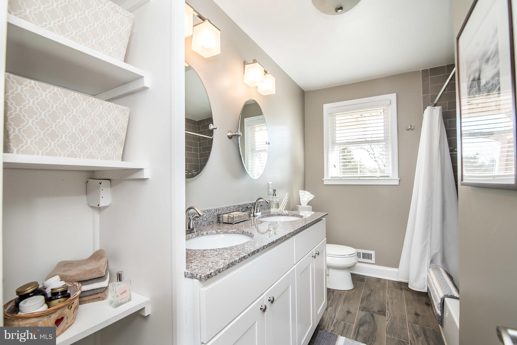 4042 High Point Road Ellicott City, MD 21042 - Photo 16 of 29 a bathroom with a granite countertop sink mirror vanity and a toilet