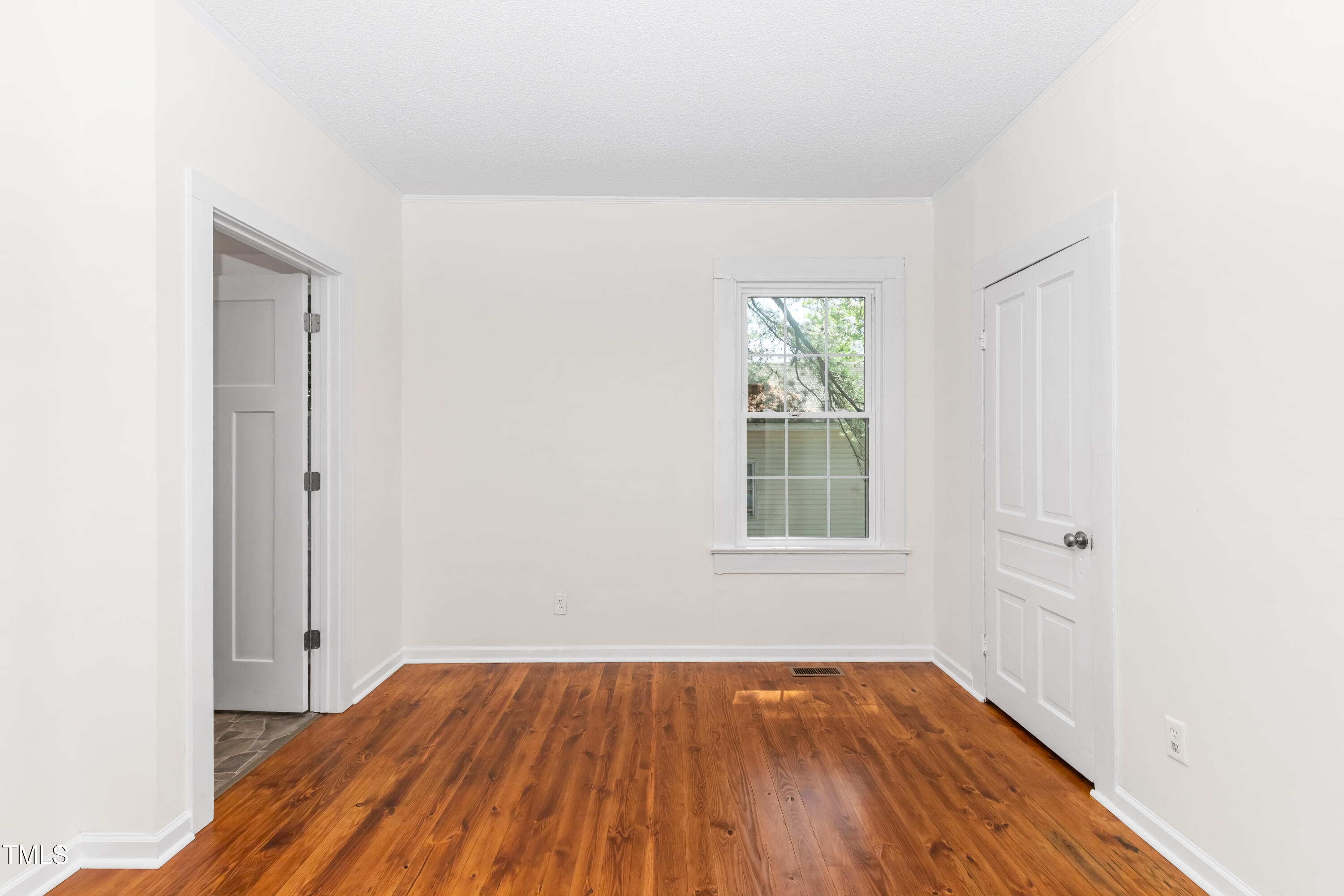 726 West M Street Erwin, NC 28339 - Photo 13 of 26 an empty room with wooden floor and windows