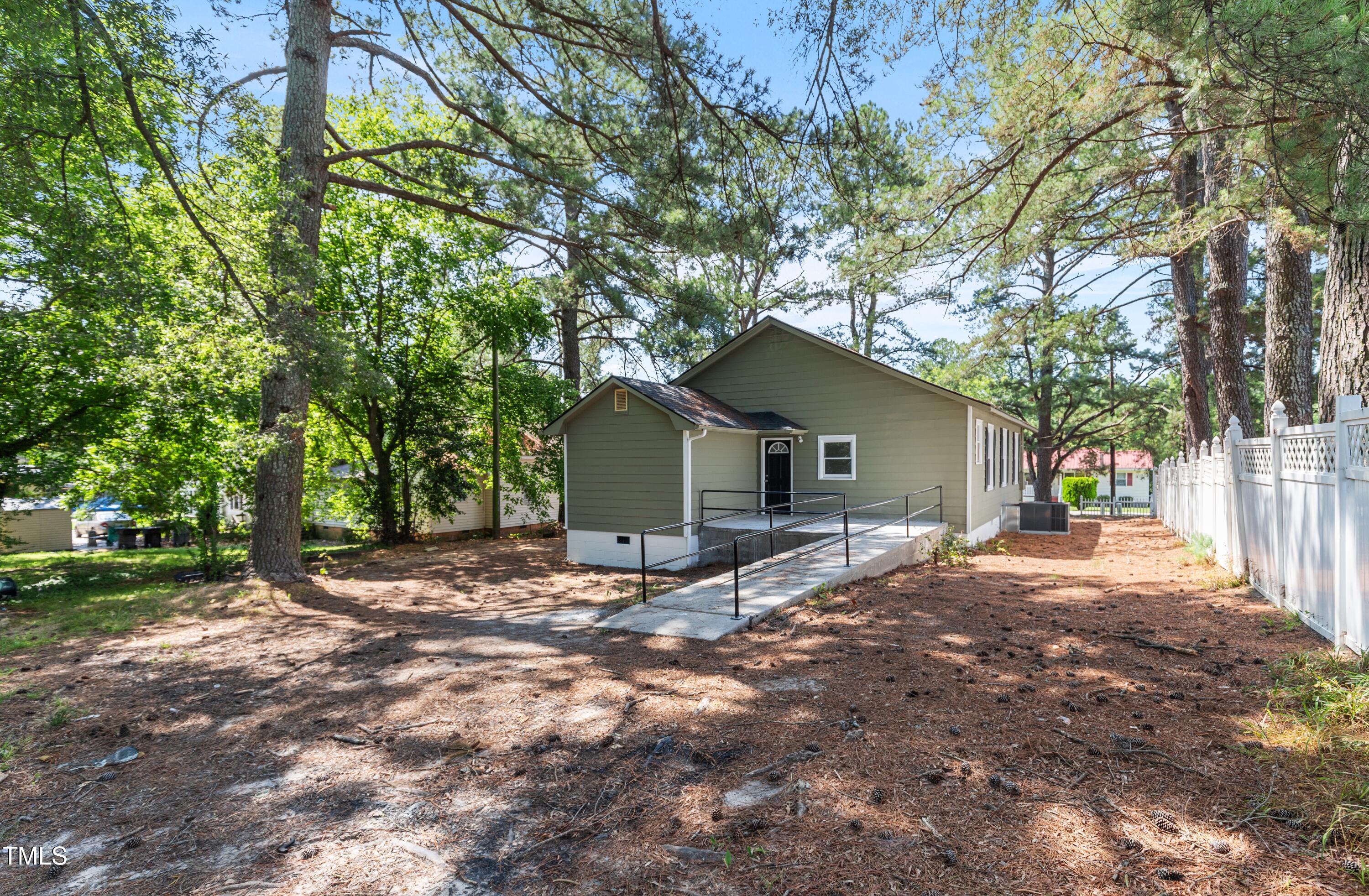 726 West M Street Erwin, NC 28339 - Photo 21 of 26 a wooden house with trees in front of it