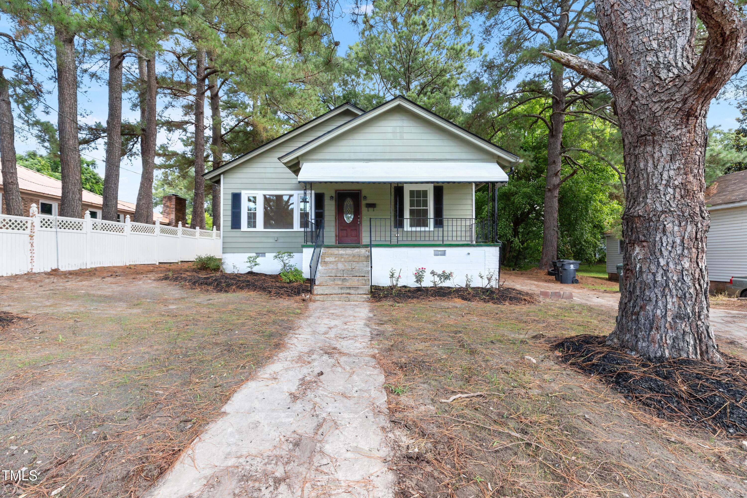 726 West M Street Erwin, NC 28339 - Photo 3 of 26 a front view of a house with a yard and garage