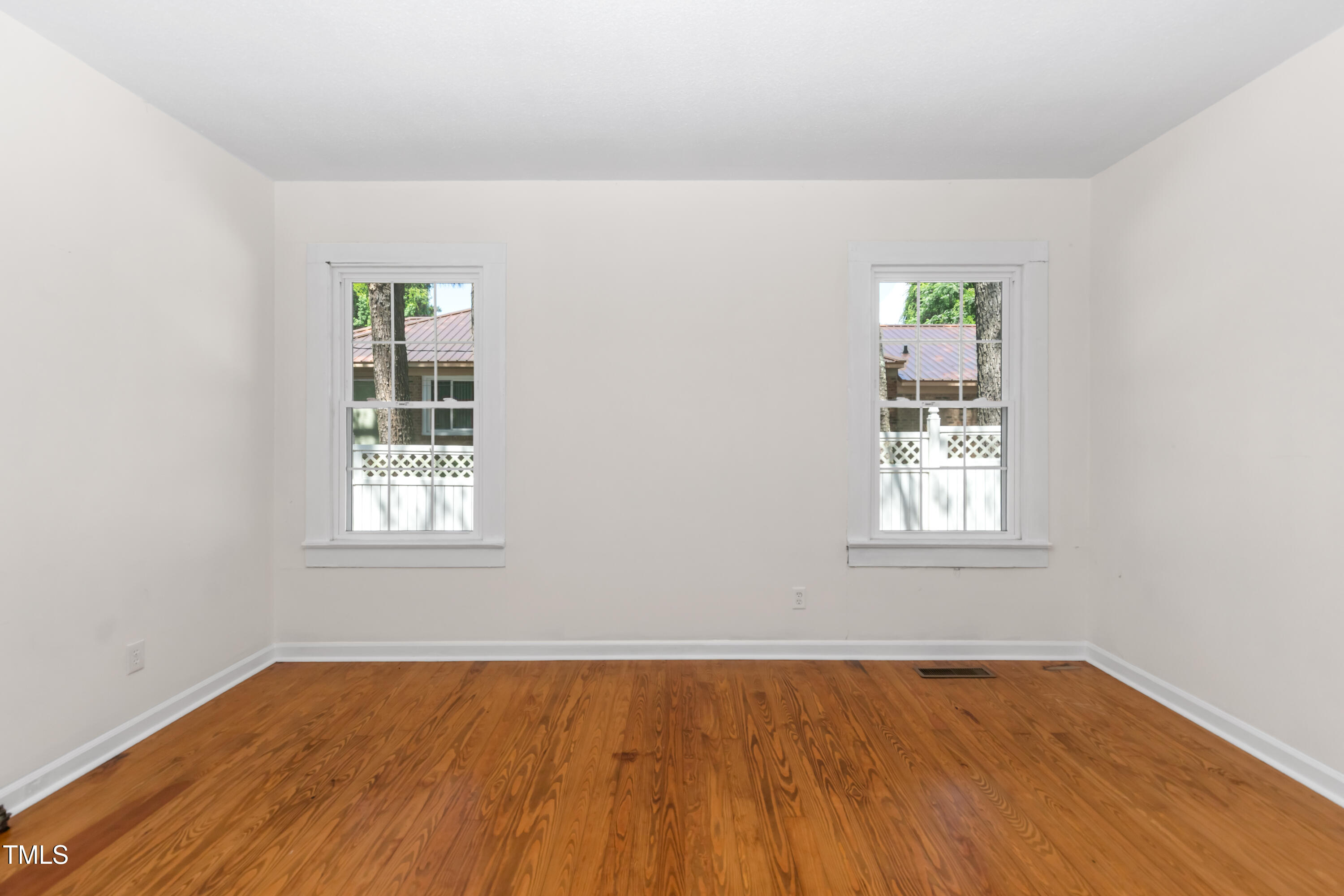 726 West M Street Erwin, NC 28339 - Photo 6 of 26 an empty room with wooden floor and windows