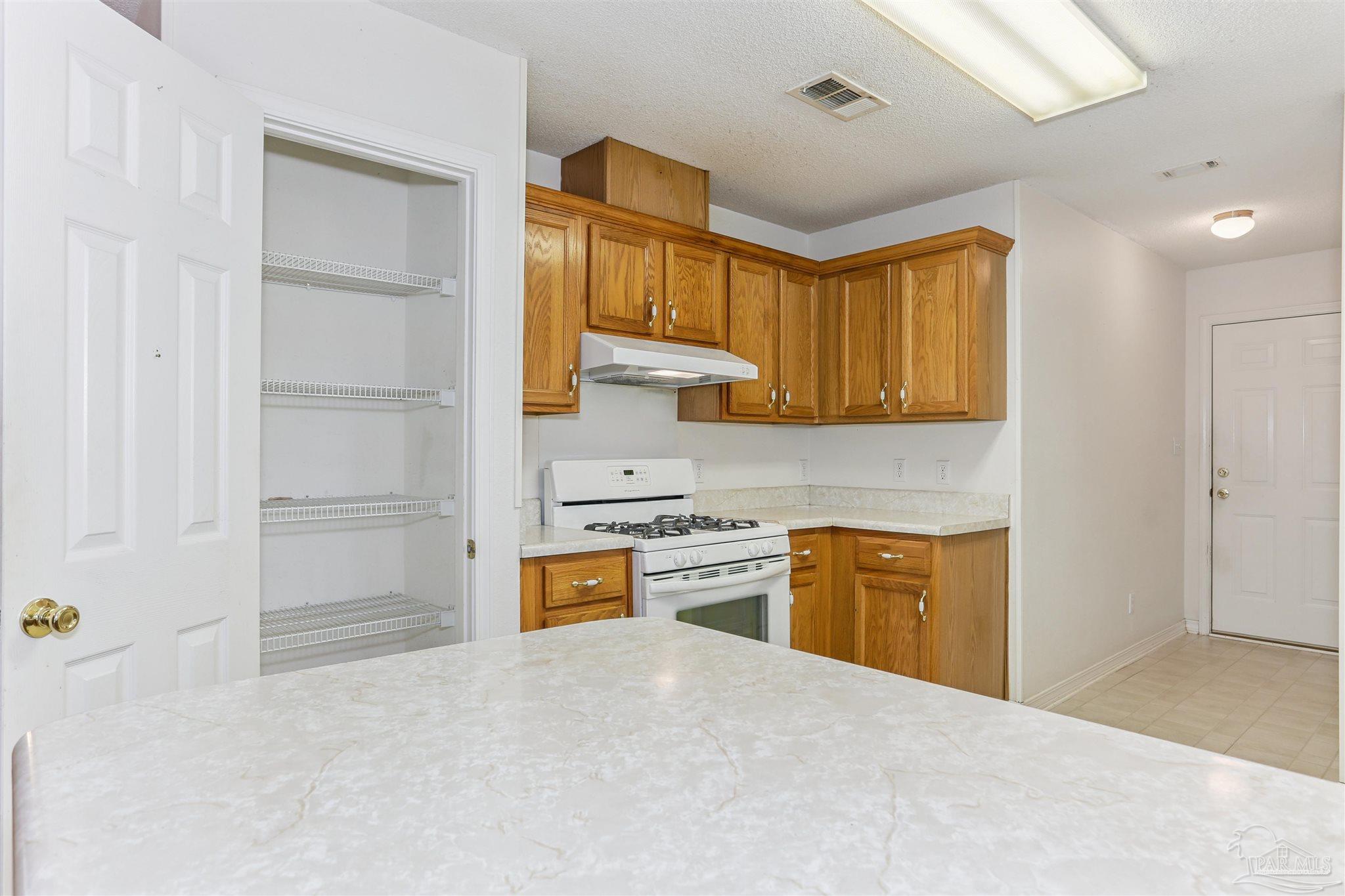 939 Avalon Boulevard Milton, FL 32583 - Photo 29 of 56 a kitchen with a refrigerator sink stove and cabinets