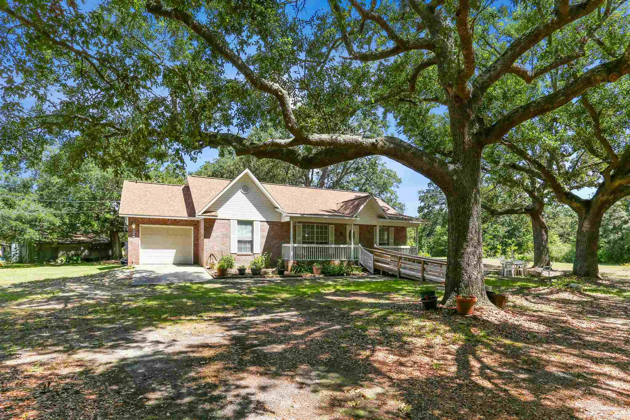 939 Avalon Boulevard Milton, FL 32583 - Photo 3 of 56 a front view of a house with a garden