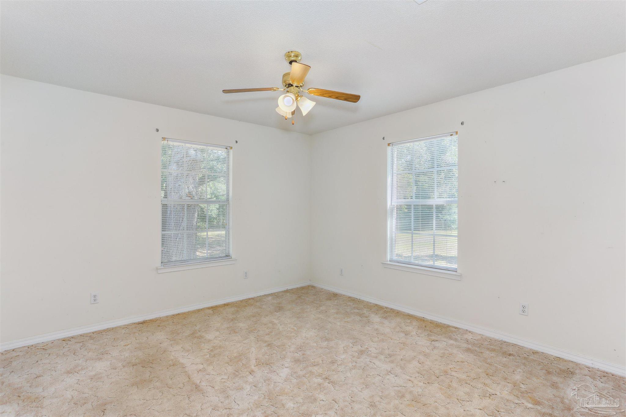 939 Avalon Boulevard Milton, FL 32583 - Photo 33 of 56 an empty room with windows and fan