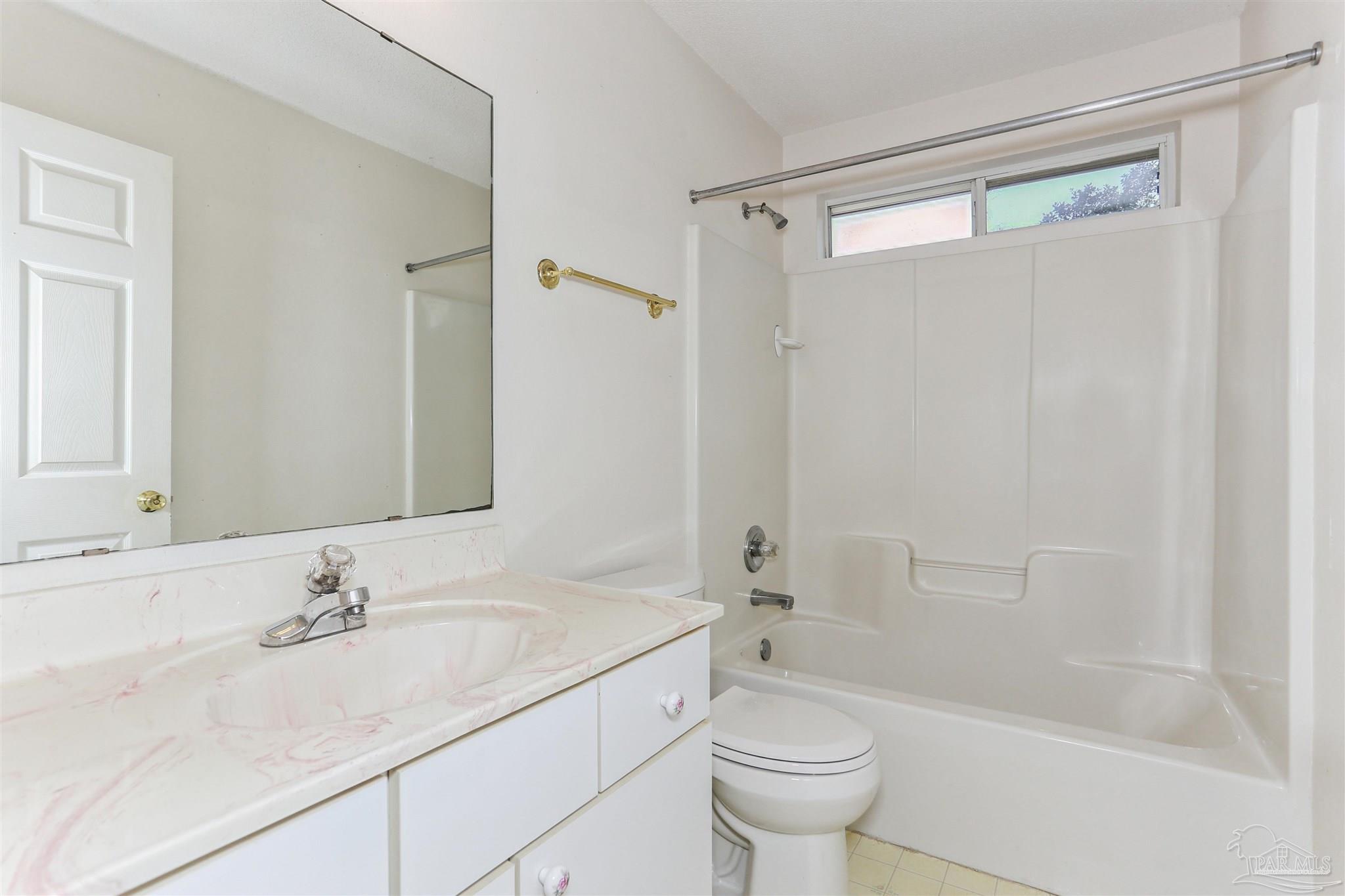 939 Avalon Boulevard Milton, FL 32583 - Photo 35 of 56 a bathroom with a granite countertop sink a toilet and shower