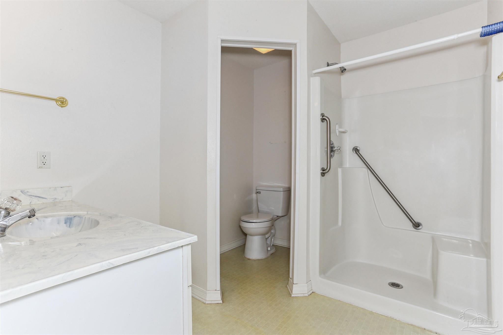 939 Avalon Boulevard Milton, FL 32583 - Photo 38 of 56 a bathroom with a granite countertop sink a toilet and shower
