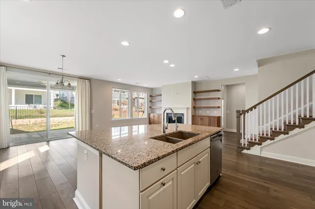 a kitchen with stainless steel appliances granite countertop a sink and wooden floor