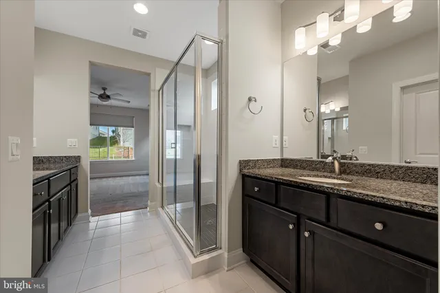 a bathroom with a granite countertop sink a large mirror and a shower