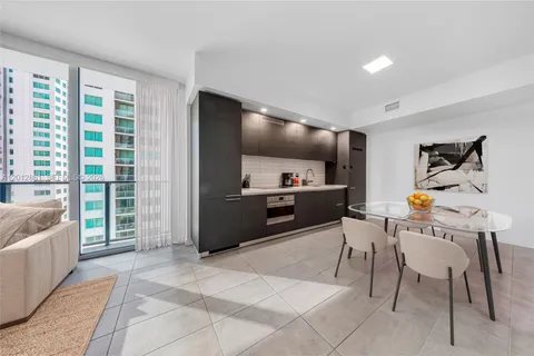 a view of a dining room with furniture a kitchen and chandelier