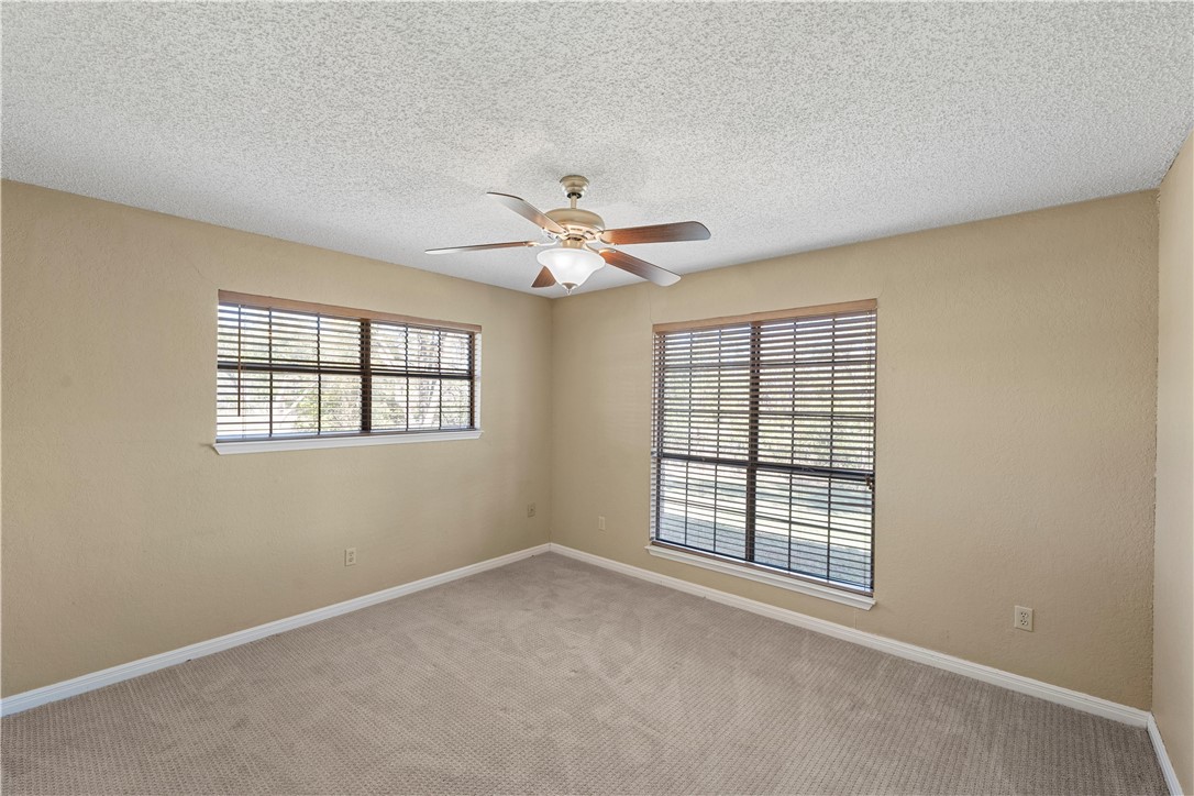 6000 Flat Rock Road Waco, TX 76708 - Photo 21 of 44 an empty room with windows and ceiling fan