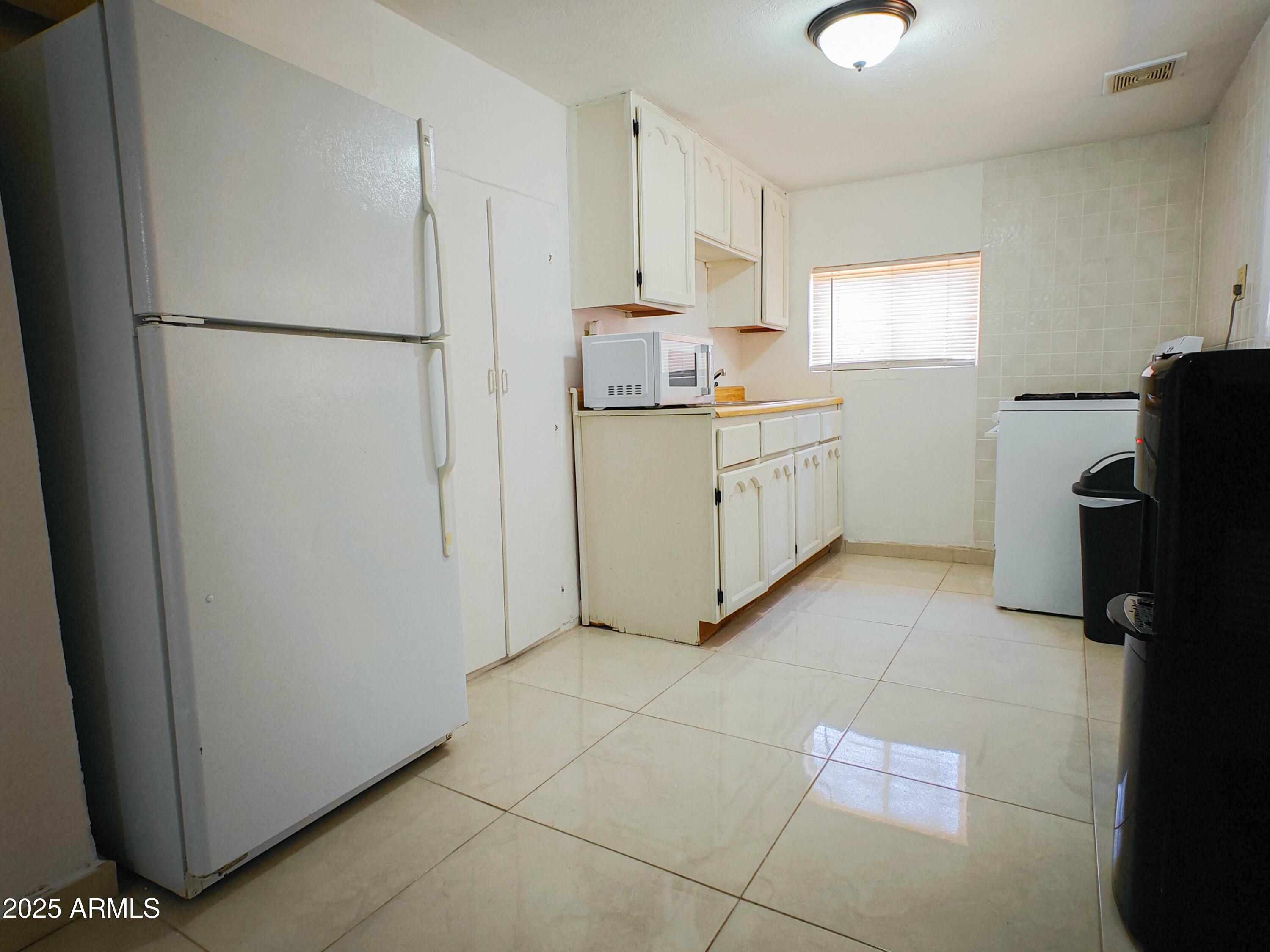 750 A Avenue Douglas, AZ 85607 - Photo 11 of 19 a kitchen with a refrigerator a stove a microwave and a window