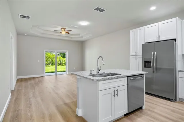 a kitchen with kitchen island a sink stainless steel appliances and cabinets