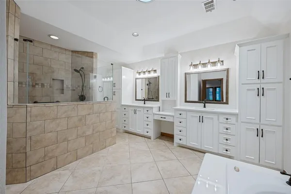 a spacious bathroom with a granite countertop sink mirror and shower