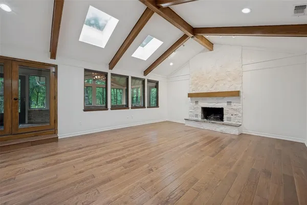 a view of empty room with wooden floor and fireplace