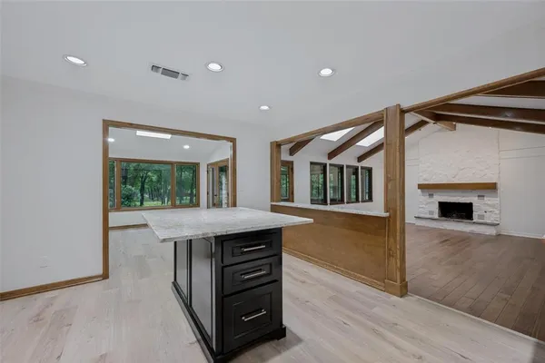 a kitchen with kitchen island a counter top space a stove and wooden floor