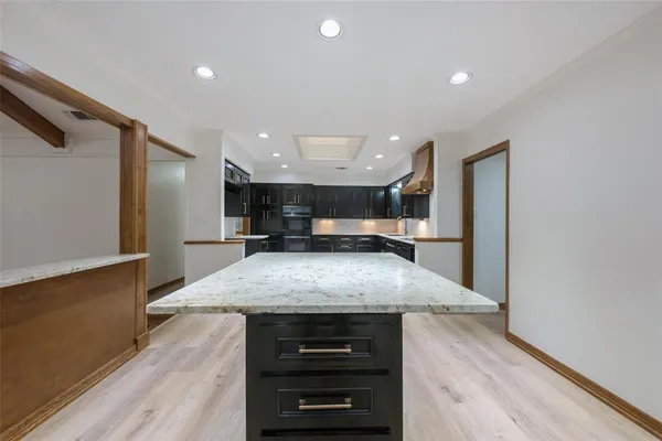 a large kitchen with a stove and a refrigerator