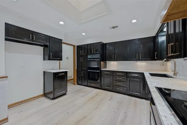 a kitchen with granite countertop a refrigerator and a stove top oven
