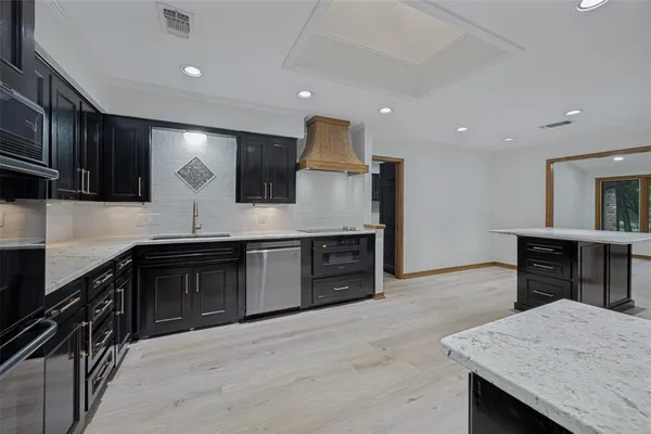 a kitchen with stainless steel appliances granite countertop wooden cabinets a stove and a sink
