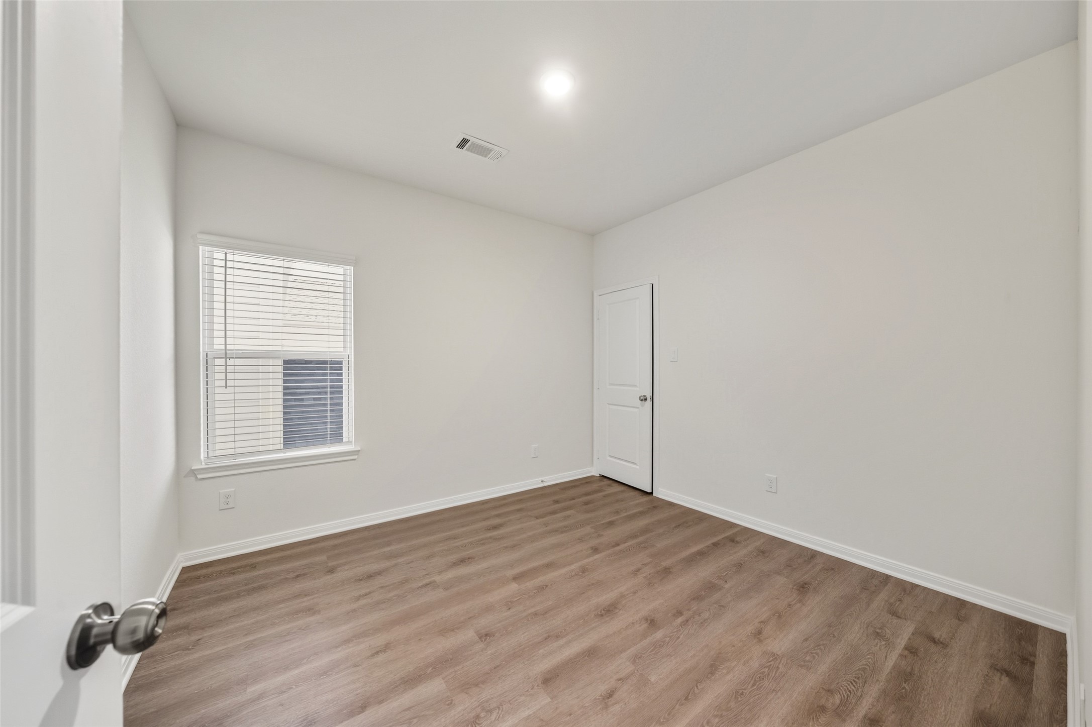 706 West Dallas Street Conroe, TX 77301 - Photo 15 of 19 an empty room with wooden floor and windows