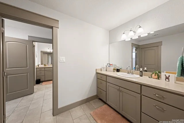 a bathroom with a glass door shower a sink and a mirror