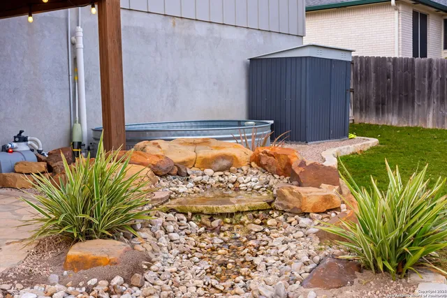 a view of a house with a big yard and large tree
