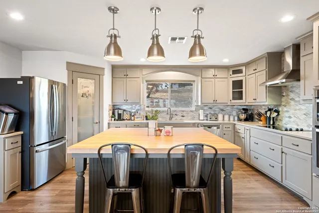 a kitchen with kitchen island a counter top space a sink appliances and cabinets