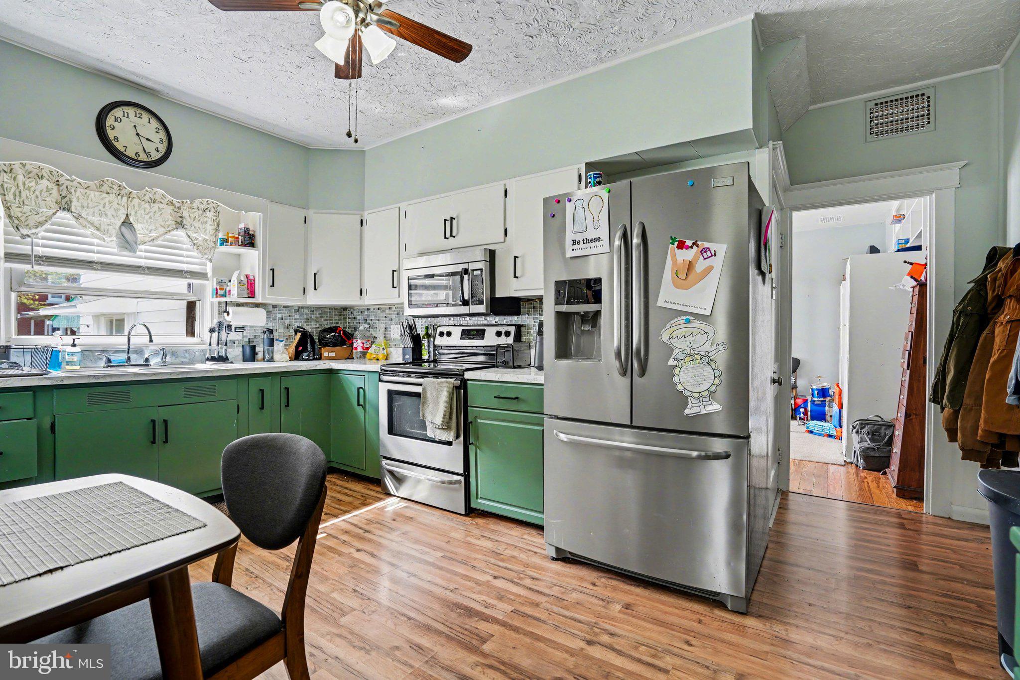 116 West Broad Street Elizabethville, PA 17023 - Photo 9 of 28 a kitchen with stainless steel appliances granite countertop a refrigerator a microwave a stove and a dining table with wooden floor