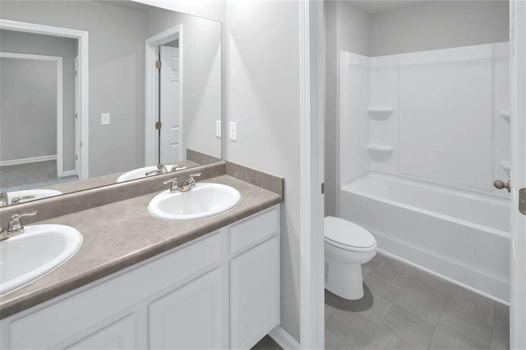 205 Lauritsen Way Newnan, GA 30265 - Photo 16 of 22 a bathroom with a granite countertop sink toilet and shower