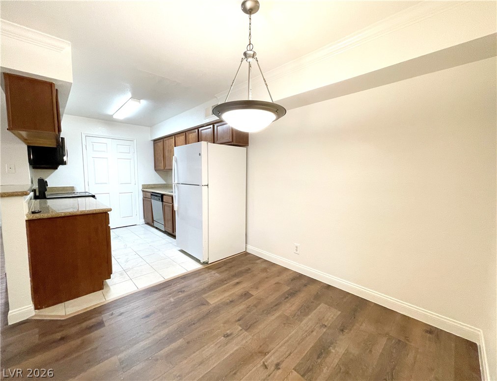 3135 South Mojave Road, Unit 221 Las Vegas, NV 89121 - Photo 4 of 19 A combined kitchen and dining space featuring rich wood-look flooring and a functional layout.