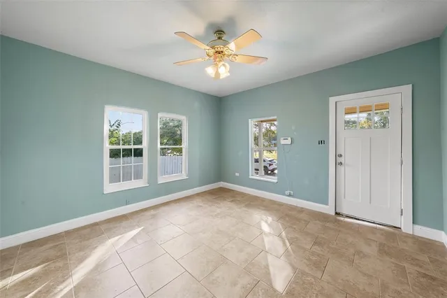 an empty room with fan and windows
