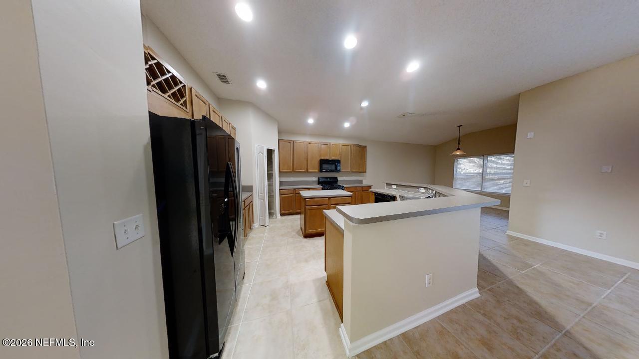 14454 Millhopper Road Jacksonville, FL 32258 - Photo 5 of 44 a kitchen with stainless steel appliances granite countertop a refrigerator a sink and a stove with wooden floor