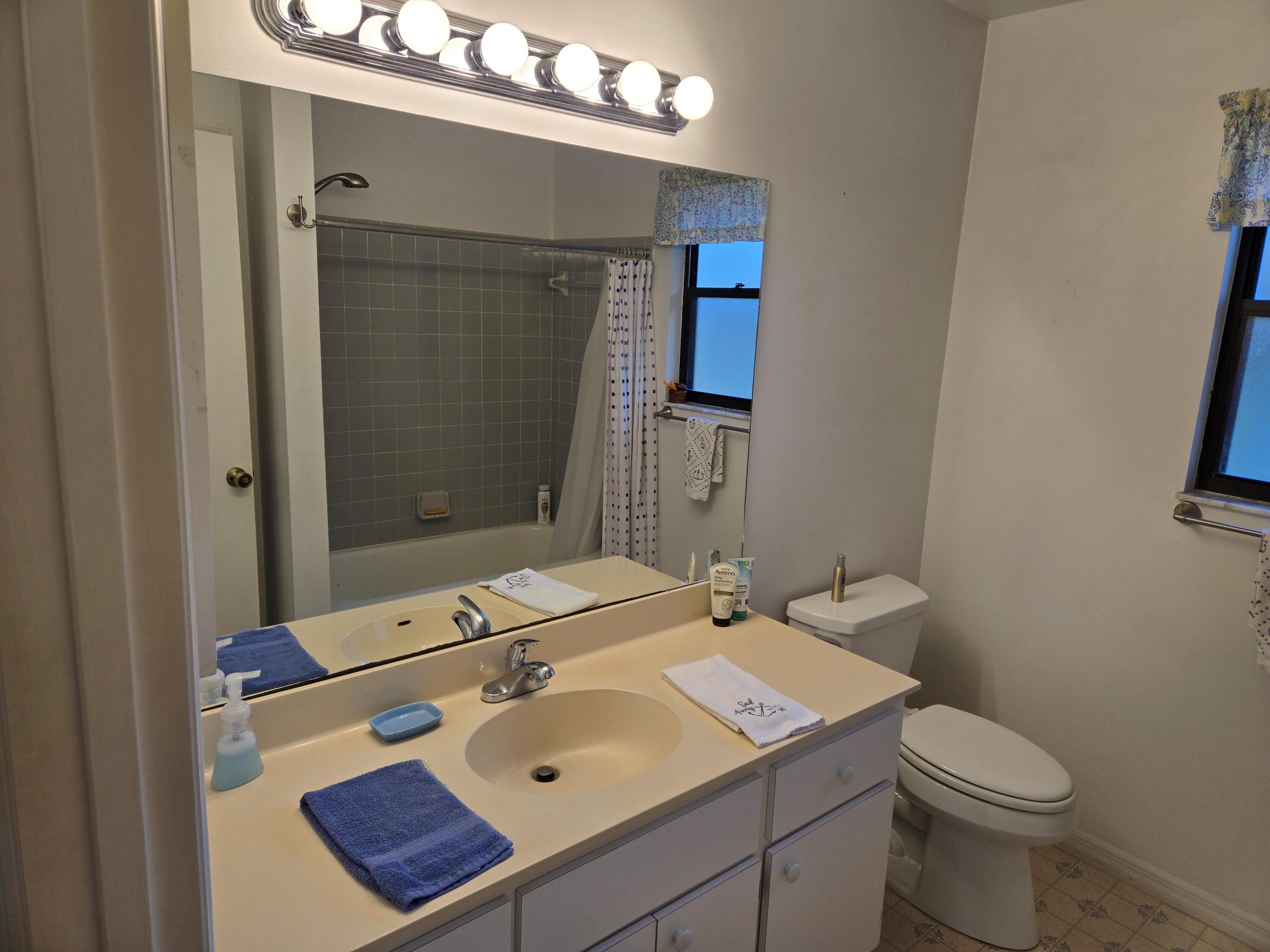 390 Main Street Sebastian, FL 32958 - Photo 11 of 18 a bathroom with a sink and mirror with toilet