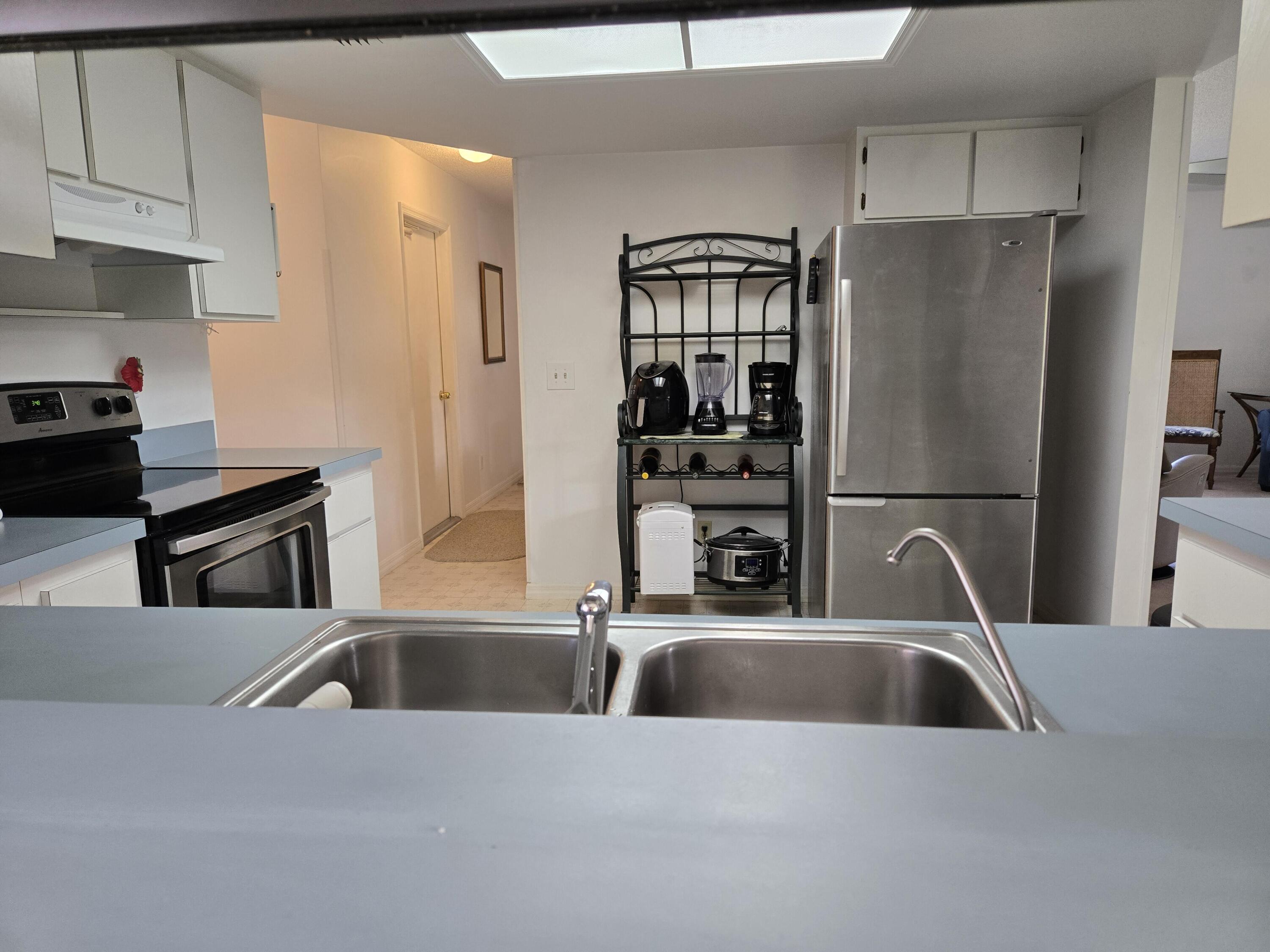 390 Main Street Sebastian, FL 32958 - Photo 4 of 18 a kitchen with a sink a refrigerator and cabinets