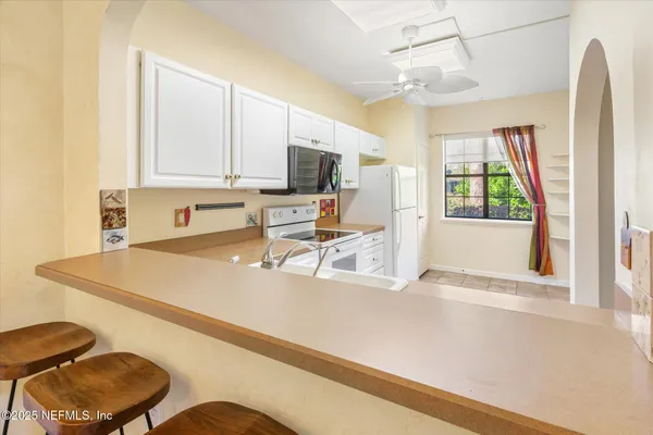 a kitchen with a stove a refrigerator and a sink with cabinets